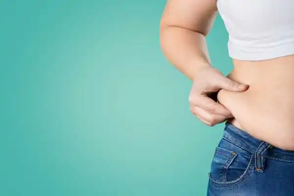 Image of woman pinching her love handles to show weight gain Moseley